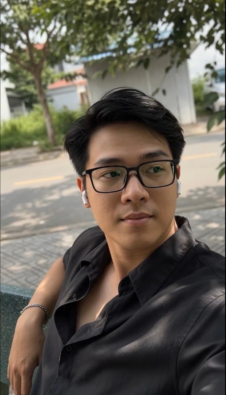Khoa wearing glasses while seated outdoors during the day